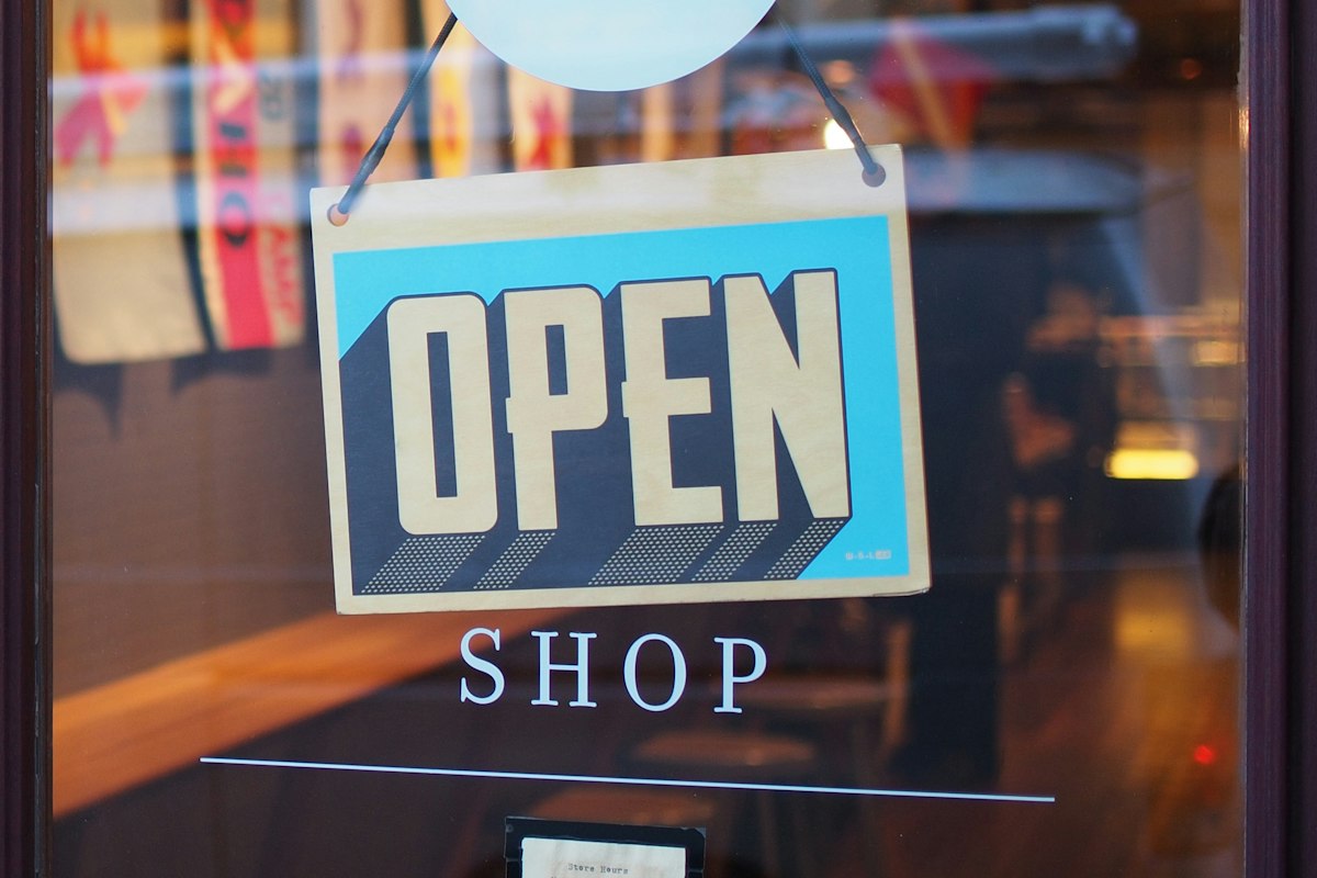 Local storefront owner helping a customer — unique FAQ imagery