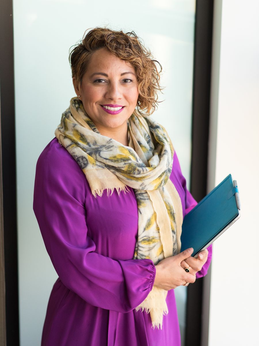 Smiling local business owner holding a teal folder